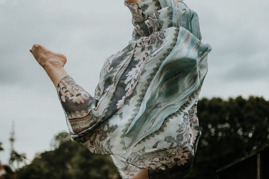 Person performing a slow flowing movement against dark background.